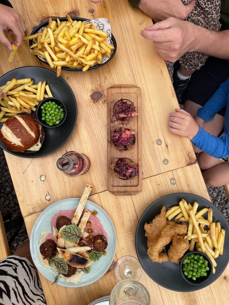 A table of food including chips and fish, beef burgers. Pig and Whistle South Lakes pub